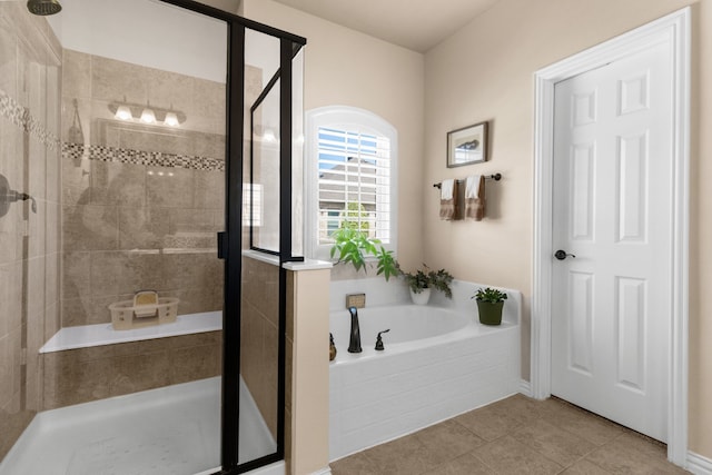 bathroom featuring a stall shower, a garden tub, and tile patterned flooring