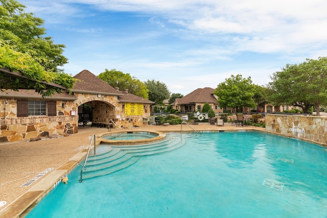 view of pool featuring a patio and a pool with connected hot tub
