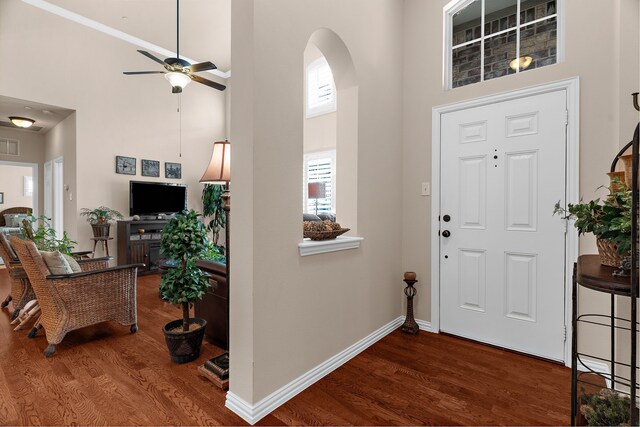 entrance foyer with baseboards, wood finished floors, a towering ceiling, and a ceiling fan