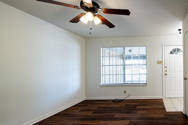 foyer entrance with baseboards, wood finished floors, and a ceiling fan