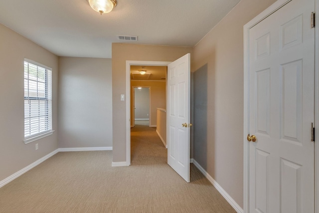bedroom with visible vents, baseboards, and light colored carpet