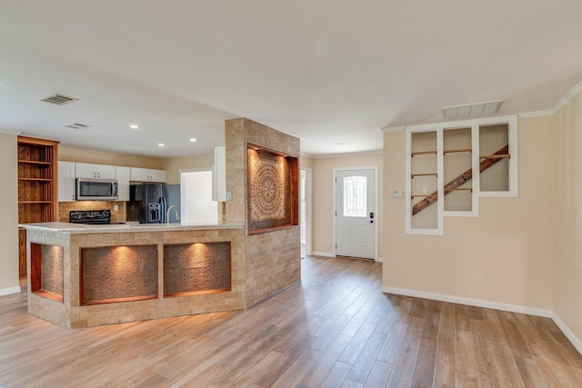 kitchen with light wood-type flooring, visible vents, white cabinetry, and black appliances