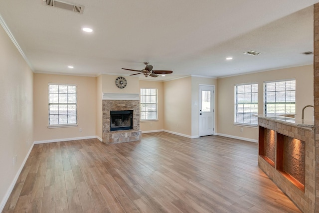 unfurnished living room with visible vents, light wood-type flooring, crown molding, and ceiling fan