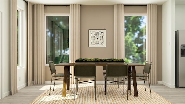 dining area with baseboards and wood finished floors