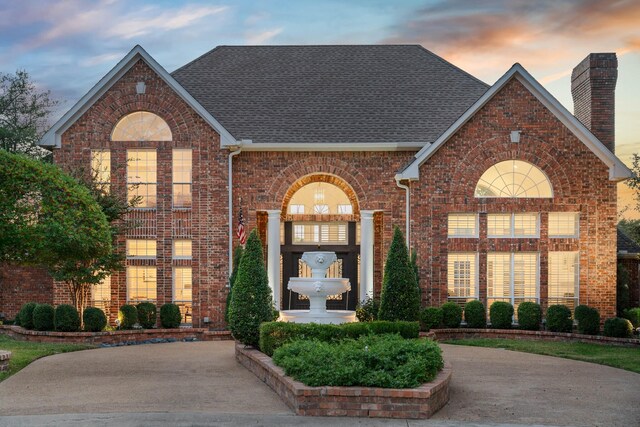 4580 Southgate Dr, Plano, TX 75024 - traditional home featuring brick siding, a chimney, and a shingled roof