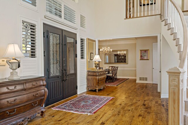 4580 Southgate Dr, Plano, TX 75024 - entrance foyer with a towering ceiling, stairway, a chandelier, wood finished floors, and baseboards