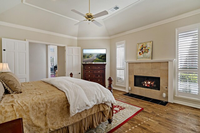 4580 Southgate Dr, Plano, TX 75024 - bedroom with wood finished floors, lofted ceiling, a tile fireplace, ornamental molding, and a ceiling fan