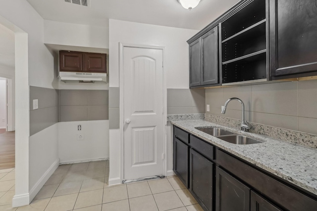 322 W Mcvey Ave, Dallas, TX 75224 - kitchen featuring open shelves, a sink, light tile patterned floors, light stone counters, and under cabinet range hood