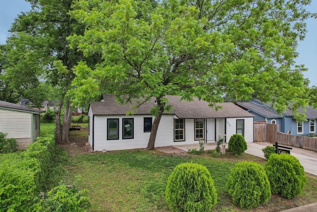 322 W Mcvey Ave, Dallas, TX 75224 - view of front facade featuring fence, roof with shingles, and a front lawn