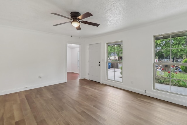 322 W Mcvey Ave, Dallas, TX 75224 - unfurnished room with a ceiling fan, a textured ceiling, a healthy amount of sunlight, and wood finished floors