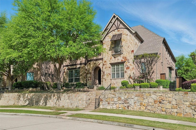 tudor home with brick siding and stone siding