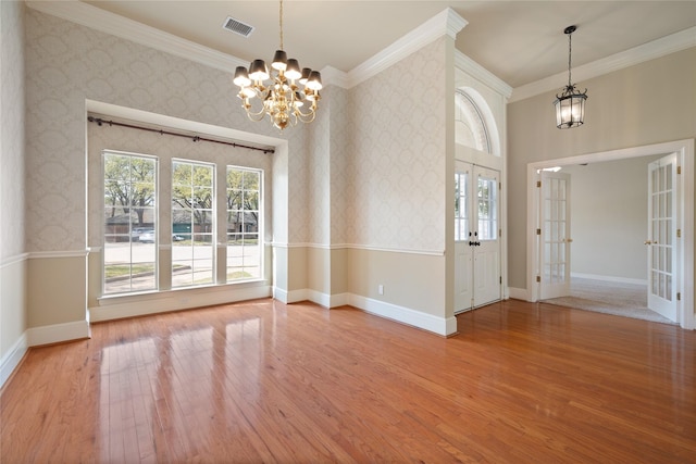 2411 Oak Shadow Ct, Arlington, TX 76017 - empty room featuring a chandelier, wood finished floors, crown molding, baseboards, and wallpapered walls