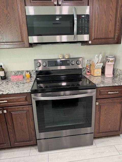 kitchen featuring stainless steel appliances and light stone counters