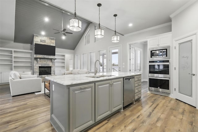 1011 Cardinal Cv, Graford, TX 76449 - kitchen featuring a sink, stainless steel appliances, ceiling fan, a fireplace, and decorative light fixtures