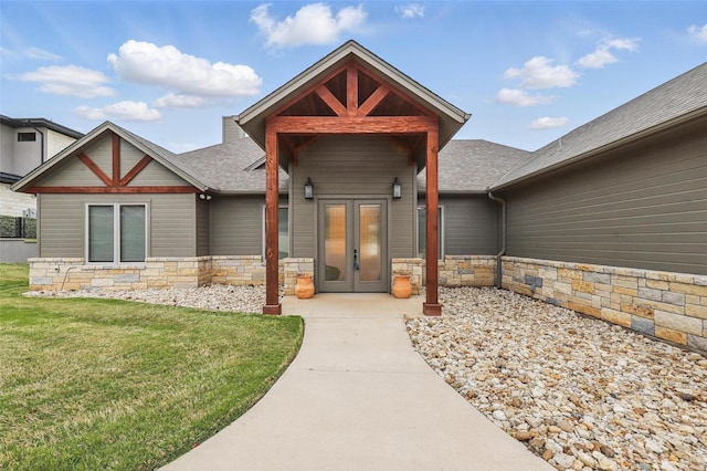 1011 Cardinal Cv, Graford, TX 76449 - view of exterior entry with stone siding, roof with shingles, french doors, and a yard
