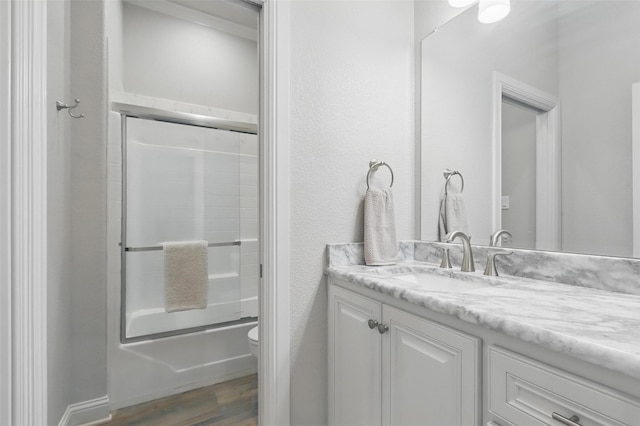 1011 Cardinal Cv, Graford, TX 76449 - full bathroom with toilet, vanity, wood finished floors, and bath / shower combo with glass door