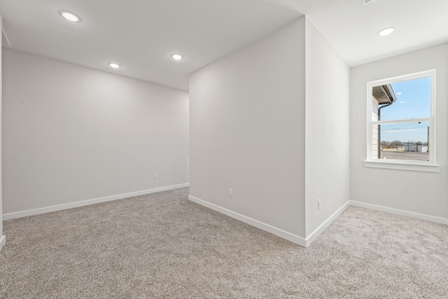 carpeted spare room featuring baseboards and recessed lighting