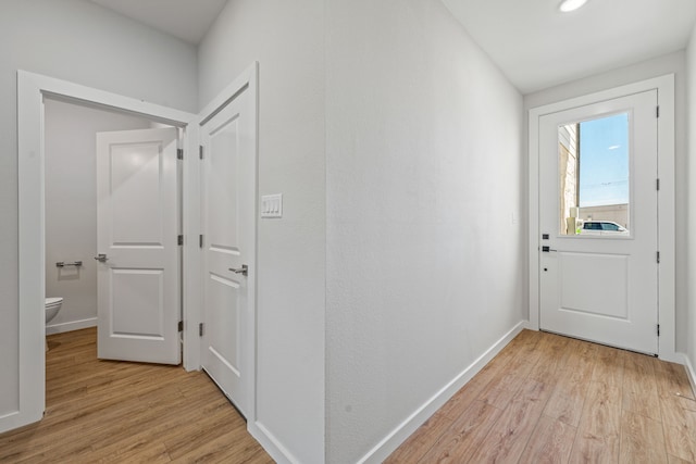 interior space with baseboards and light wood-style floors