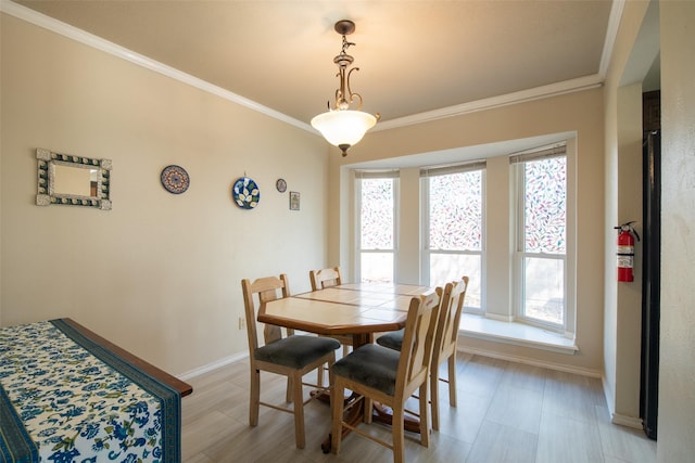 dining room featuring crown molding and baseboards