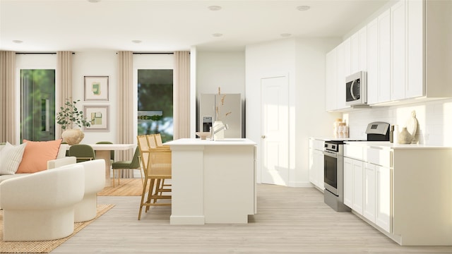 kitchen with white cabinets, stainless steel electric range oven, white fridge with ice dispenser, a center island with sink, and backsplash