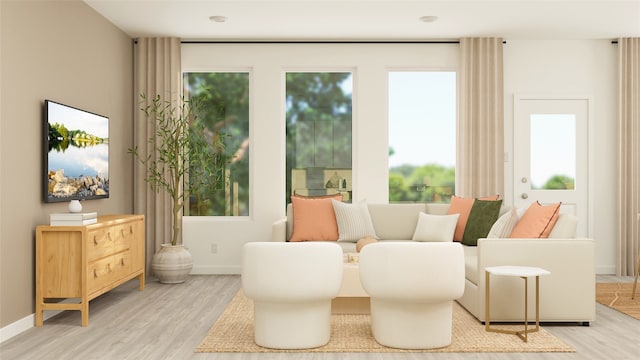 living area with baseboards, a wealth of natural light, and light wood finished floors