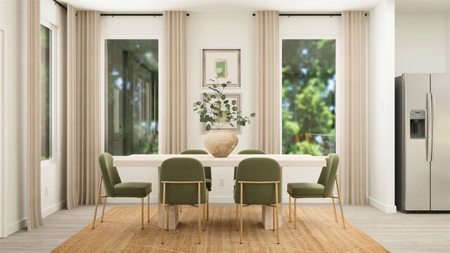 dining space with baseboards and wood finished floors