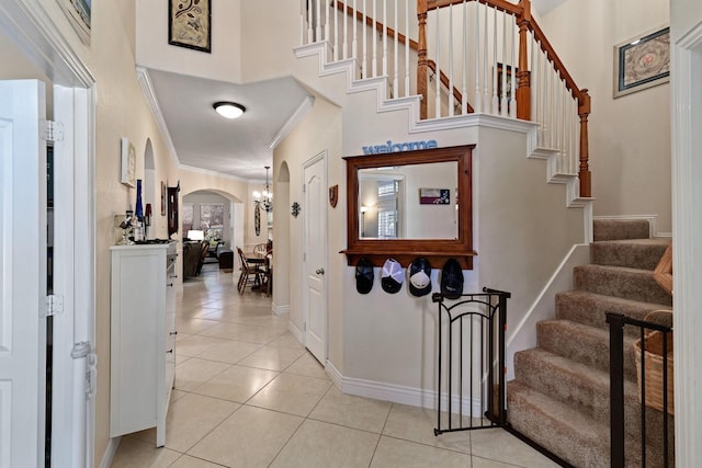 1431 Bonham Pkwy, Lantana, TX 76226 - foyer entrance featuring arched walkways, ornamental molding, light tile patterned flooring, stairs, and a high ceiling