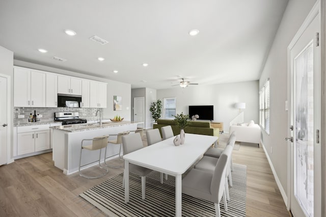 709 Caraway Dr, Princeton, TX 75071 - kitchen with black microwave, stainless steel gas range, healthy amount of natural light, backsplash, and recessed lighting