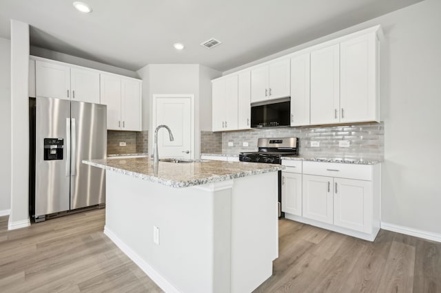 709 Caraway Dr, Princeton, TX 75071 - kitchen with stainless steel appliances, a sink, light wood finished floors, a center island with sink, and recessed lighting