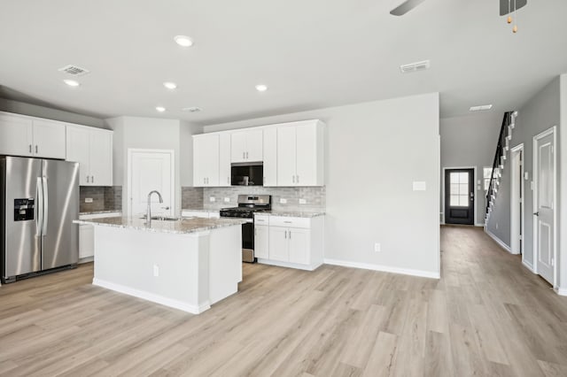 709 Caraway Dr, Princeton, TX 75071 - kitchen with stainless steel appliances, a sink, tasteful backsplash, light wood finished floors, and recessed lighting
