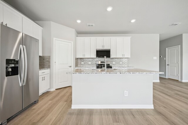 709 Caraway Dr, Princeton, TX 75071 - kitchen with stainless steel appliances, light wood finished floors, tasteful backsplash, white cabinets, and recessed lighting