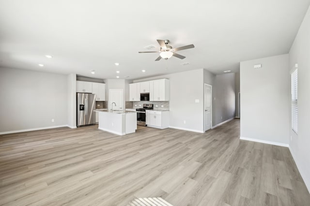 709 Caraway Dr, Princeton, TX 75071 - unfurnished living room featuring a ceiling fan, baseboards, recessed lighting, light wood-style floors, and a sink