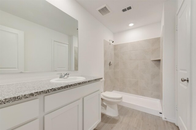 bathroom featuring vanity, visible vents, toilet, and a shower stall