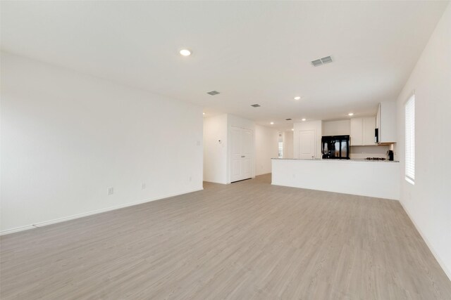 unfurnished living room featuring baseboards, visible vents, recessed lighting, and light wood-type flooring