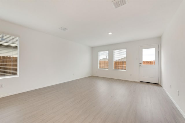 empty room featuring baseboards, recessed lighting, visible vents, and light wood-style floors