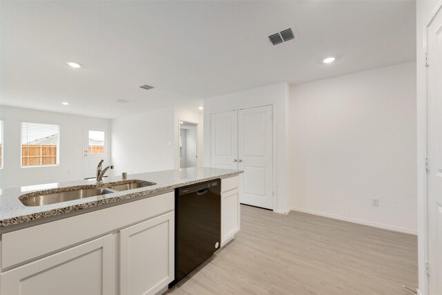 kitchen featuring a sink, visible vents, light stone counters, and dishwasher