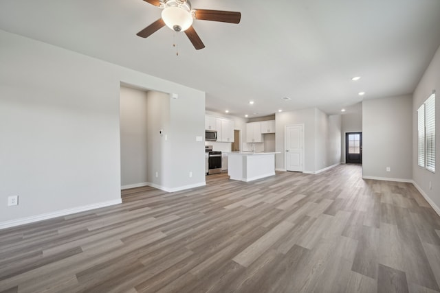 unfurnished living room with baseboards, light wood-style flooring, recessed lighting, and a ceiling fan