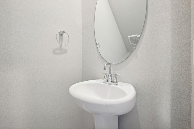 bathroom with a sink and a textured wall