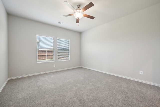 spare room with carpet, baseboards, ceiling fan, and visible vents