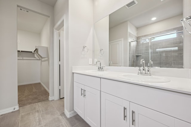 bathroom with visible vents, a sink, a stall shower, and double vanity