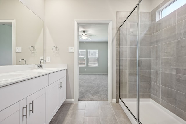 bathroom featuring double vanity, a sink, a ceiling fan, and a shower stall