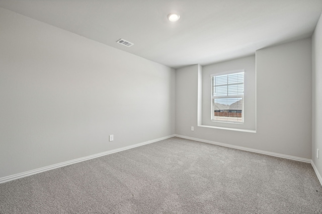 carpeted spare room with baseboards and visible vents