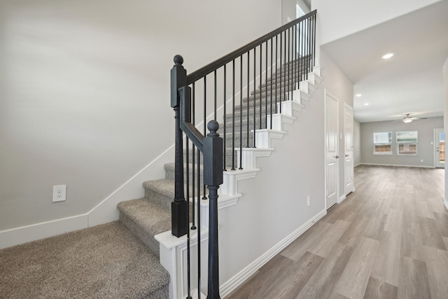 staircase featuring baseboards, wood finished floors, recessed lighting, and a ceiling fan