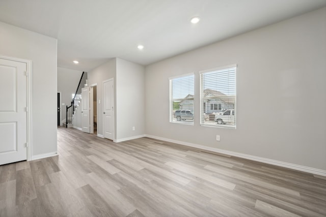 spare room with baseboards, light wood-style flooring, and recessed lighting