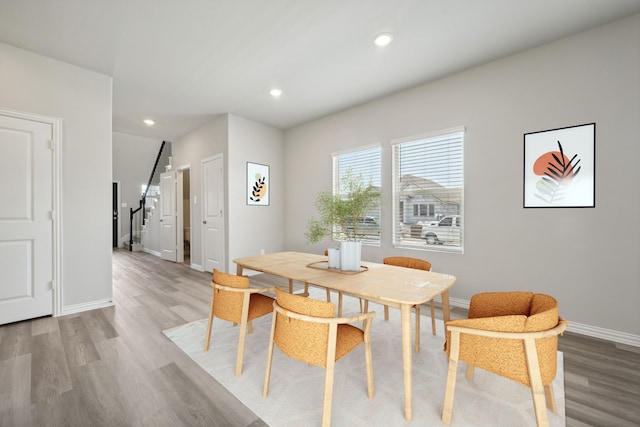 dining space featuring baseboards, wood finished floors, and recessed lighting