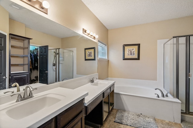 bathroom featuring a garden tub, a sink, a stall shower, and a walk in closet