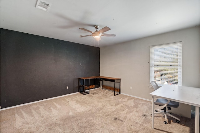 carpeted home office featuring baseboards, ceiling fan, and visible vents