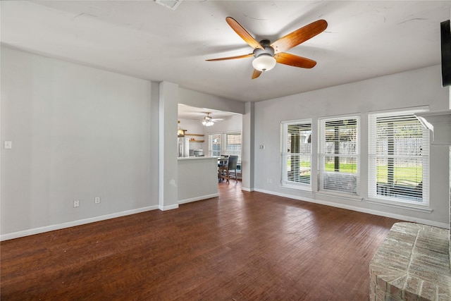 unfurnished living room with baseboards, wood finished floors, and ceiling fan
