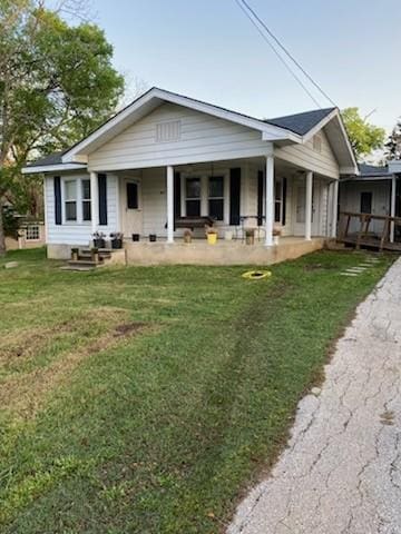 rear view of property with a lawn and driveway