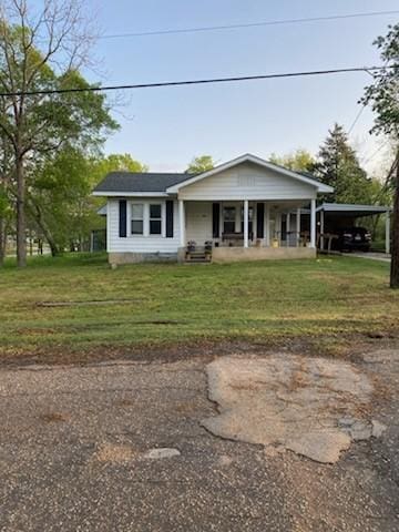 view of front of home with an attached carport, driveway, covered porch, and a front yard